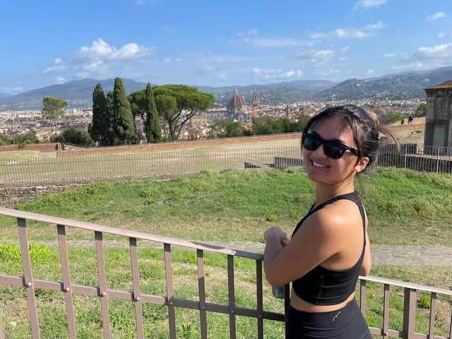 Lynn Dang on a hike with Florence's city center in the background